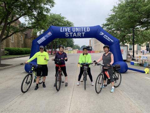 4 bicyclists pose at the start line of the road race. 