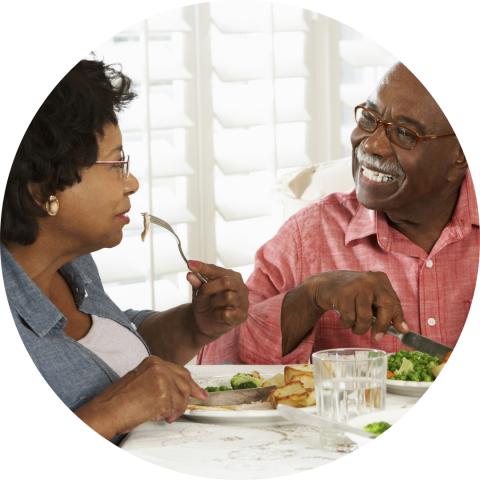 Two seniors smiling over their healthy dinner