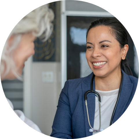 Latino woman who is a doctor smiling at a patient 