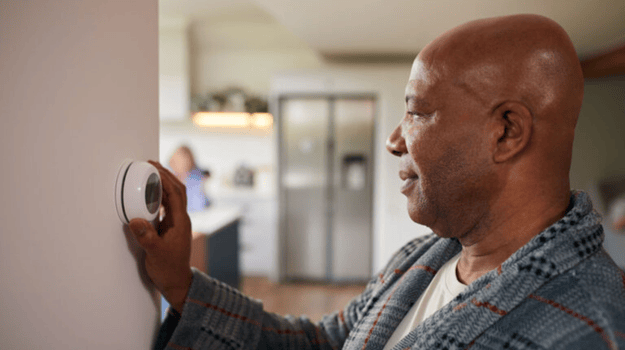 Man adjusting his thermostat